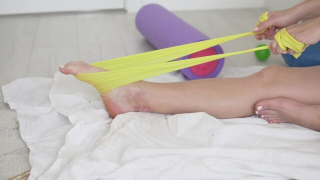 A woman does gymnastics during rehabilitation after an achilles tendon injury.