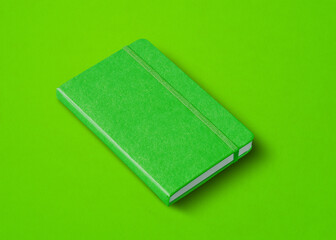 Green closed notebook isolated on color background