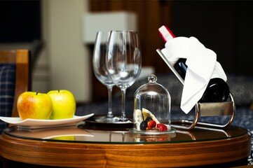 Obraz premium Honeymoon celebration with wine tasting and food pairing. Luxurious bottle of wine on the wine stand and gourmet food.