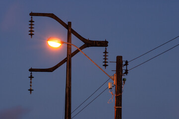 Electrification poles with late afternoon sky in the background.