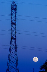 Electrification tower with moon in the blue background.