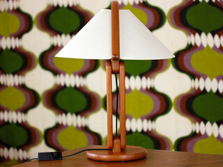 A vintage modern desk lamp from the 60s made out of tak wood standing on a desk isolated on white background very rare in original condition design icon close up living room minimalistic danish design