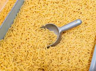 Pasta by weight in a supermarket, dough products on a store counter