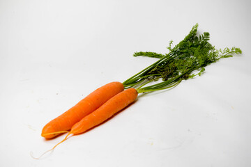 Two carrots with tops, isolated on a white background