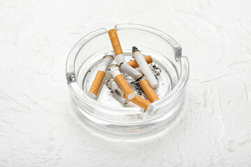 Ash tray with cigarettes on light background