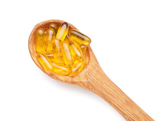 Spoon with fish oil capsules on white background