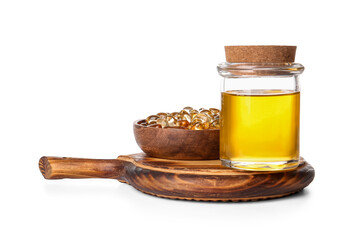 Bottle of fish oil and bowl with capsules on white background