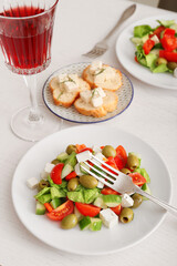 Plates with fresh Greek salad on table in restaurant