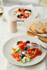 Plates with fresh Greek salad on table in restaurant