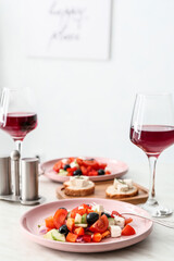 Plates with fresh Greek salad on table in restaurant