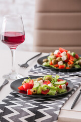 Plates with fresh Greek salad on table in restaurant