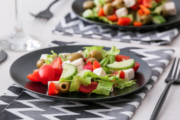 Plates with fresh Greek salad on table in restaurant, closeup