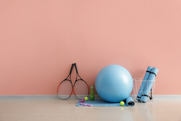 Set of sports equipment with fitness ball on color background