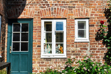 Fototapeta na wymiar Dolls in the window of a typical town house