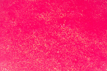Saturated pink slime with golden glitter particle texture, top view.
