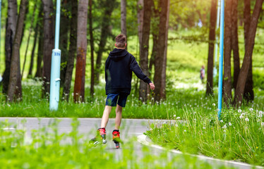 A guy and on roller skates rides in the Park
