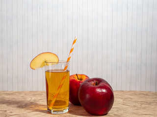 Fresh apple juice with straws in a glass.