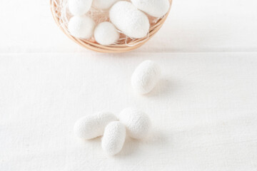 white silkworm cocoons shells, source of silk fabric in the basket