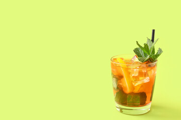 Glass of tasty ice tea with lemon on color background