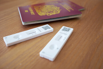 Close-up view of two British passports with two COVID tests showing negative results.