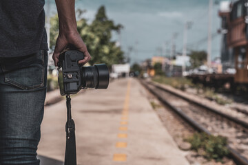 Tourists stand holding digital cameras near train tracks. concept of tourism and travel