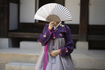 Woman in Korean traditional clothes holding Korean traditional fan