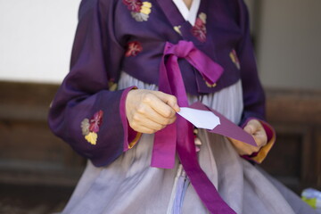Fototapeta na wymiar Woman in Korean traditional clothes holding gift envelope