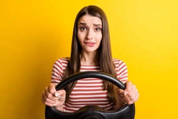 Portrait of attractive confused girl holding steering wheel driving biting lip worrying isolated...