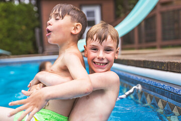 Two boy brother having fun in Pool on the summer time