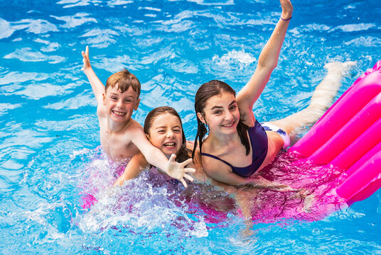 group of children having fun in Pool on the summer time - Powered by Adobe