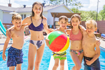 group of children having fun in Pool on the summer time