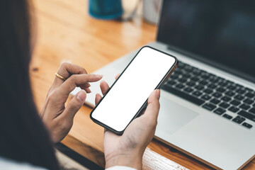 Close-up of woman hand holding a smartphone blank white screen. Mock up.
