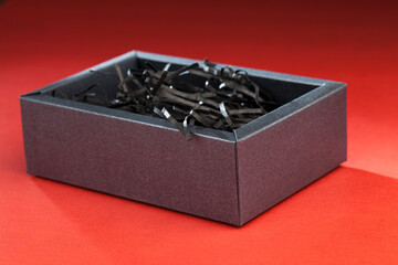 black box with cut lines of black paper