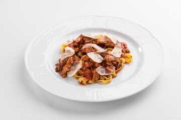 fettuccine pasta with pork and tomato sauce on white plate isolated on white background