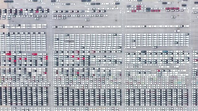 Cars export terminal in export and import business and logistics. Shipping cargo to harbor. Aerial view of a large number of new cars lined up outside an automobile factory ready to ship over sea.