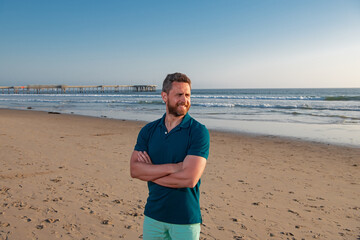 Portrait of man on beach. Outdoor portrait of handsome man posing at beach, in nice sunny day, wearing casual sorts classic t-shirt.