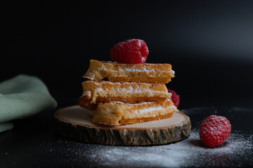 Three waffles stacked, garnished with raspberries, close up