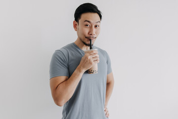 Asian man drinking boba tea or bubble tea deliciously isolated on white background.