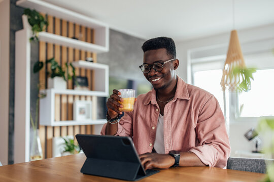 Adult black man, taking a work break, in home office.