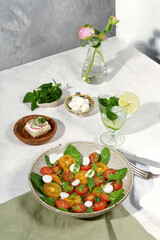 Composition with salad and cocktail with mint.
