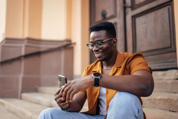 Adult black man, taking his own picture, outside.