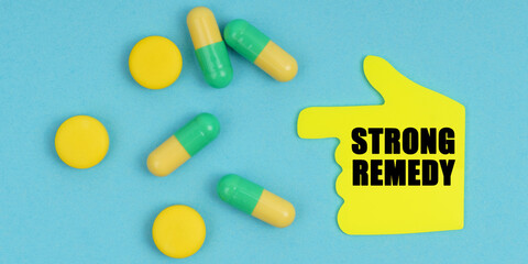 On a blue background, there are pills and a hand-sticker with the inscription - Strong remedy