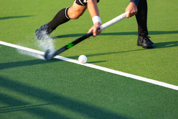 Field hockey player on artificial grass play field.