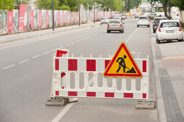 Road signs on the reconstructed street on a plastic fence warning of street's repair
