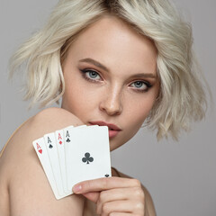 Portrait of a beautiful girl holding four ace cards in her hand. Luck concept.