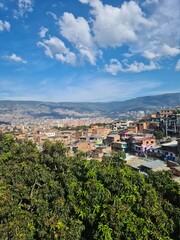 Fototapeta na wymiar Cityscape with view of the commune 13 and blue sky. Medellin, Antioquia, Colombia.