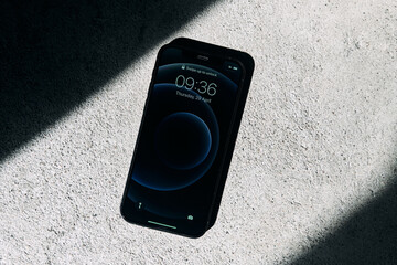 Kaliningrad, Russia - April 15, 2021: Black Apple iPhone 12 on a gray background. Latest model...
