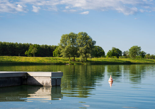 Colorful Lake with a Tree in the middle and a jetty on the left 