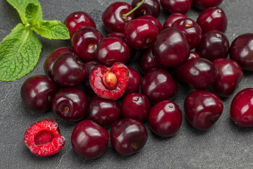 Ripe cherries and mint leaves. Half cherry, pulp and kernel of cherry