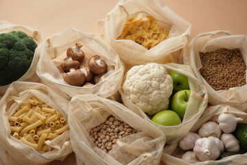 Various vegetables, pasta, mushrooms and cereals in reusable fabric eco bags. Reusable eco-friendly products. Zero waste and sustainable plastic free lifestyle. View from above.